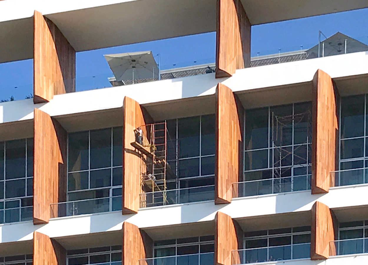 Tower Five A - Eighth Floor units are two story Penthouse 1 BR Loft Residences.  Here, workers are staining the wooden separation strures.  Above the Penthouse units is the Rooftop Pool and