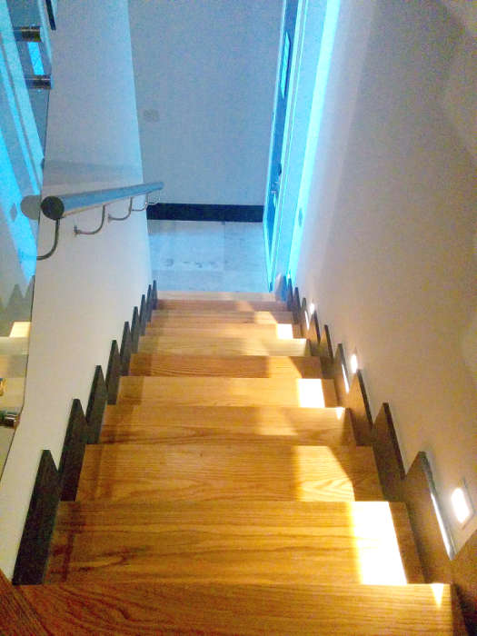 The stairs are well lit and have railings.  This photo shows the good lighting that accents the stairwell.
